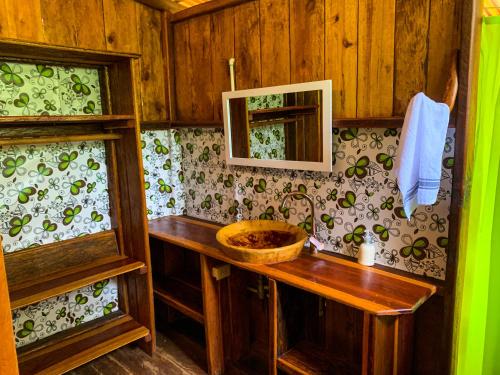 La salle de bains est pourvue d'un lavabo en bois et d'un miroir. dans l'établissement Mama Yeya raíces, à San Cipriano