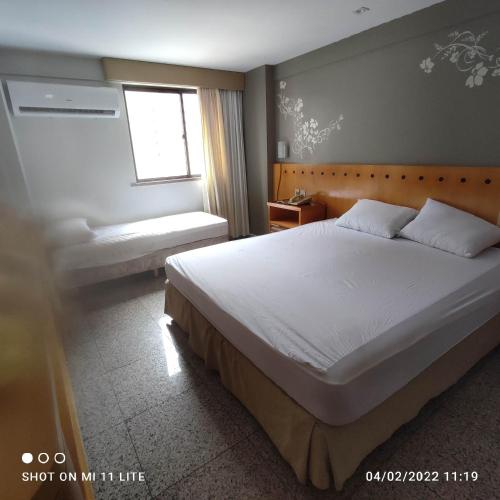 a bedroom with a large bed and a window at BEIRA MAR MEIRELES in Fortaleza