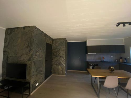 Vikavegen Stryn في سترين: غرفة معيشة مع طاولة ومدفأة