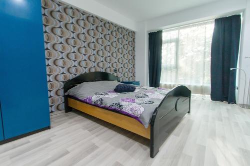 a bedroom with a bed and a large window at Aparthotel Jolie in Galaţi