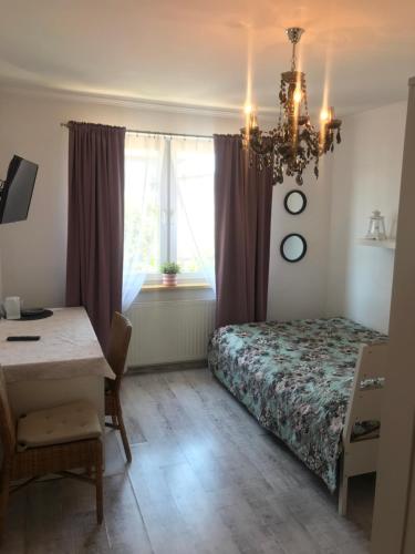 1 dormitorio con cama, escritorio y ventana en Willa Olimp, en Władysławowo