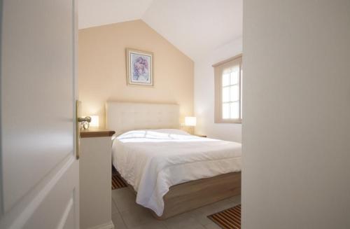 a bedroom with a white bed and a window at Charming bungalow with private garden in Maspalomas
