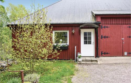 a red house with a white door and a yard at Lovely Apartment In Tjörnarp With Sauna in Tjörnarp
