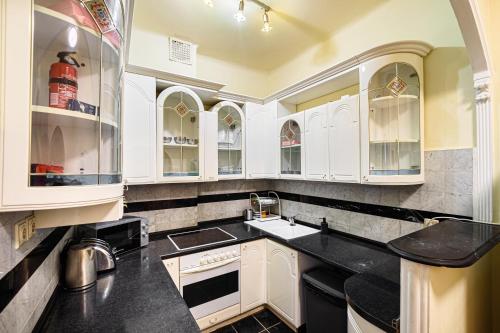 a kitchen with white cabinets and black counter tops at Stylish Homes Downtown Buda in Budapest