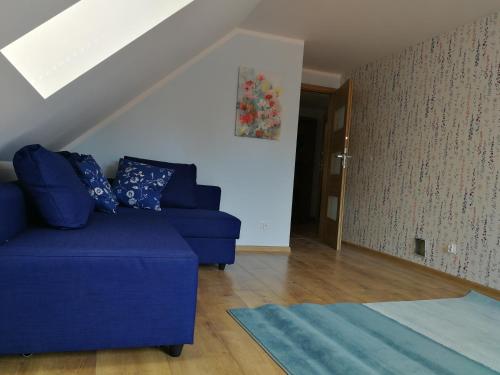 a living room with a blue couch and a staircase at Trójmiasto nad jeziorem DOM -ECHOCHATA in Kamień