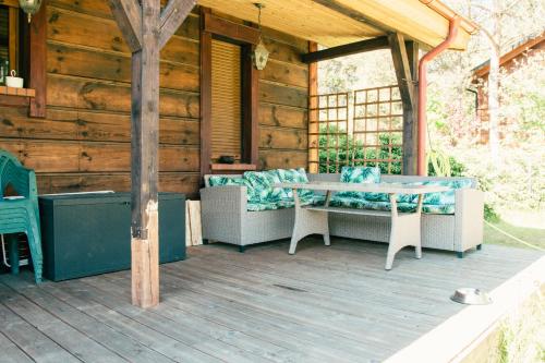 a wooden deck with a table and chairs on a cabin at Trójmiasto nad jeziorem DOM -ECHOCHATA in Kamień
