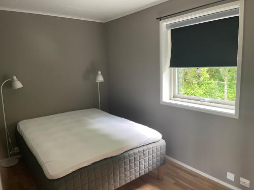 a bedroom with a bed and a window at På Taket Overnatting in Sørkjosen