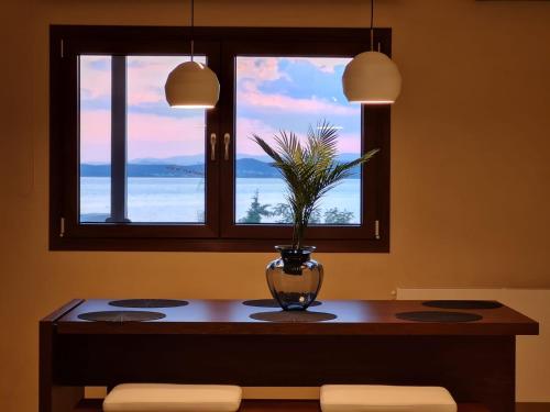 a table with a vase on it with a window at Ammos ikia in Ouranoupoli