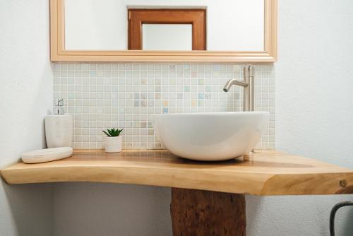 a bathroom with a bowl sink on a wooden counter at Casa Sara in Turda