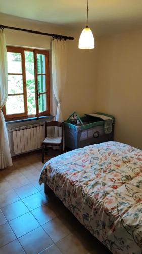 a bedroom with a bed and a desk and window at Casabonsai in Fivizzano