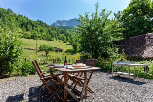 een picknicktafel met 2 stoelen en een fles wijn bij La Grange de St Même in Saint-Même