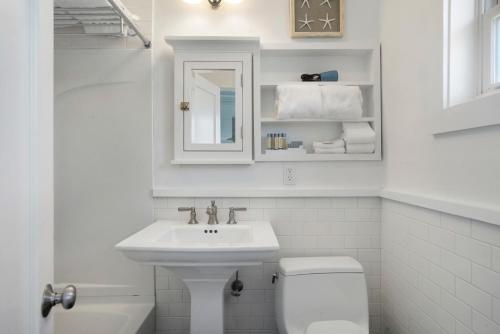 a white bathroom with a sink and a toilet at Driftwood Resort on the Ocean in Montauk