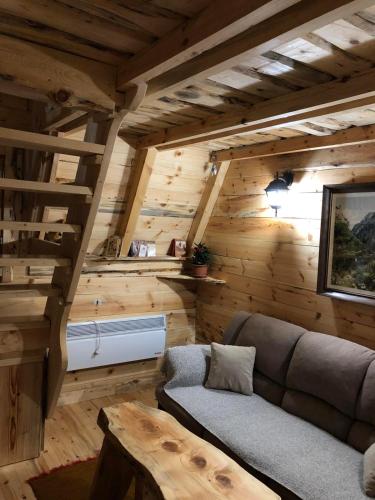 ein Wohnzimmer mit einer Couch in einer Blockhütte in der Unterkunft Cottage Bumblebee in Žabljak