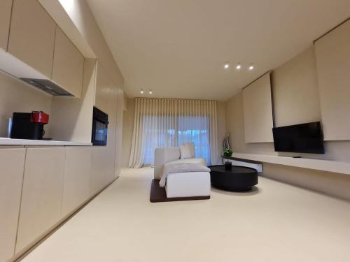 Ammos ikia في أورانوبوليس: غرفة معيشة بها أريكة بيضاء وتلفزيون