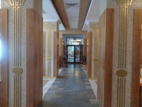 a hallway of a building with tile walls and a hallwayngth at Hotel Park Central in Sliven