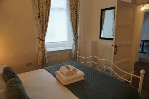 a bedroom with two towels on a bed with a window at Lake View Country House in Grasmere