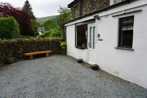 a bench sitting outside of a house with a building at Lake View Country House in Grasmere