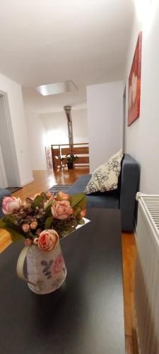 a living room with a table with a vase of flowers at Casa Bita in Sibiu