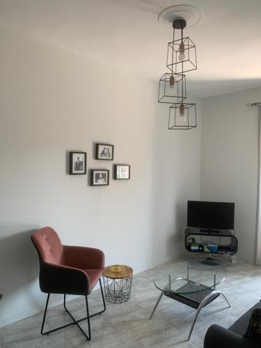 a living room with a chair and a television at Zeusplace NewWave Deluxe Apartment in Paralia Katerinis