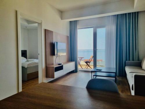 a living room with a couch and a bed and a television at Lovely Partial Sea View one bedroom flat in Horizon Residences A22 in Becici