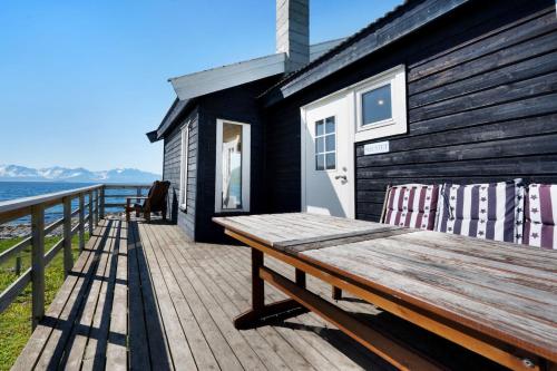 a wooden bench sitting on top of a wooden deck at Arctic FjordCamp in Burfjord