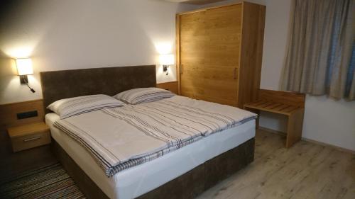 a bedroom with a bed and a wooden door at Ferienwohnung Höllwarth in Gerlos