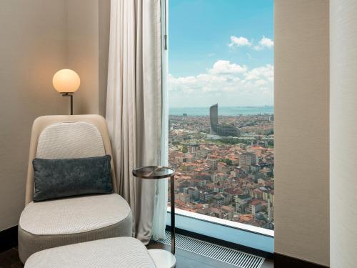 a chair in a room with a view of a city at Address Istanbul in Istanbul
