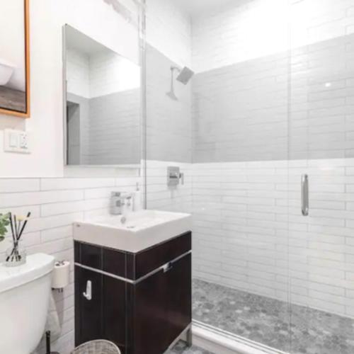 y baño con lavabo y ducha acristalada. en Modern Holiday Apartment with Strategic Location in New York, en Nueva York
