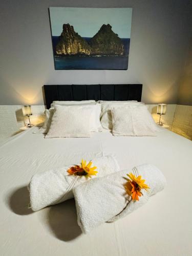a white bed with towels and flowers on it at Hostel Ilha do Amor in Fernando de Noronha