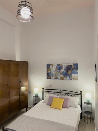 ミルトスにあるOlympios Apartment at Myrtos 1 minute from the beachのベッドルーム1室(白いシーツと黄色い枕のベッド1台付)