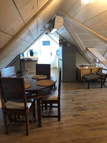a dining room with a table and chairs in a attic at Babushka Noclegi in Białowieża