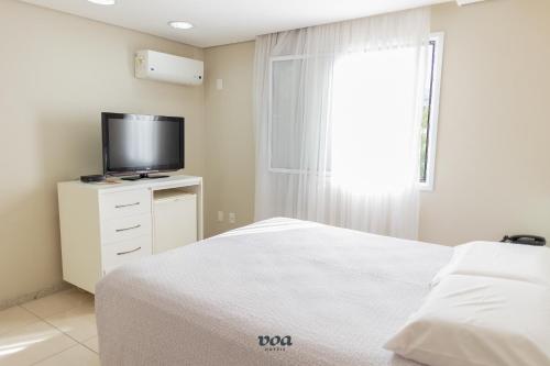 a bedroom with a bed and a flat screen tv at VOA Plazza Hotel in Águas de Lindóia