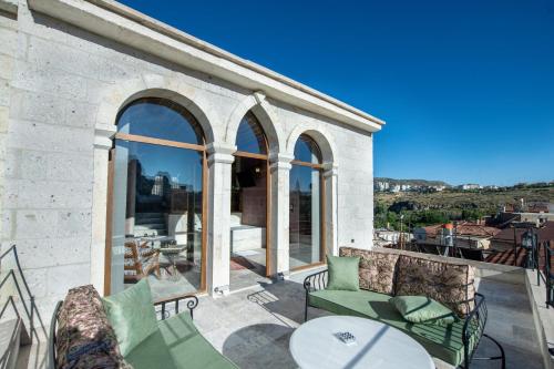 a patio with a table and chairs on a balcony at Foremanson Cave Hotel in Nar