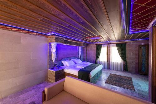 a bedroom with a bed and a couch in a room at Foremanson Cave Hotel in Nar