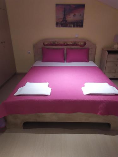 a bedroom with a large bed with purple sheets and pillows at Aegean View Seaside Apartment in Kavala