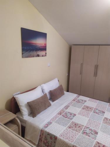 a bedroom with a bed and a painting on the wall at Aegean View Seaside Apartment in Kavala