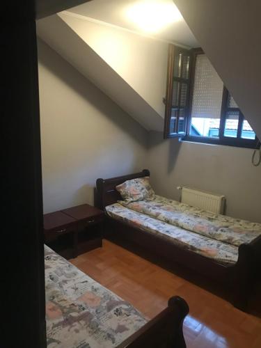 a living room with two beds and a window at Kaplarević Smeštaj Ivanjica in Ivanjica