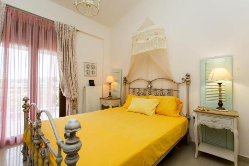 a bedroom with a yellow bed and a window at Villa Pino Pueblo in Paliouri