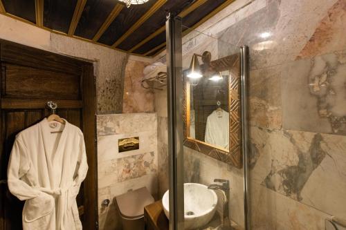 a bathroom with a shower and a sink and a mirror at Foremanson Cave Hotel in Nar