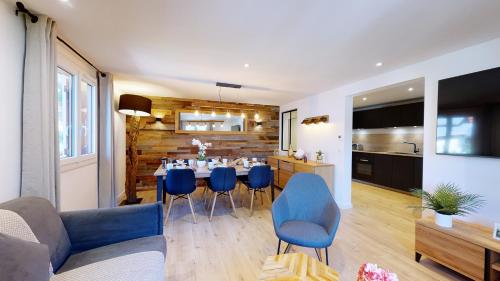 a living room with a table and blue chairs at Élégant et Moderne avec Vue Montagne au Coeur de Paradiski - Garage - 8pers - 90m2 - Sabaudinha in Champagny-en-Vanoise