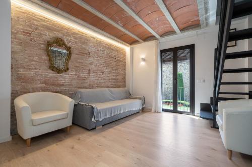 a living room with a bed and a brick wall at Hauzify I Apartaments Montblanc in Montblanc