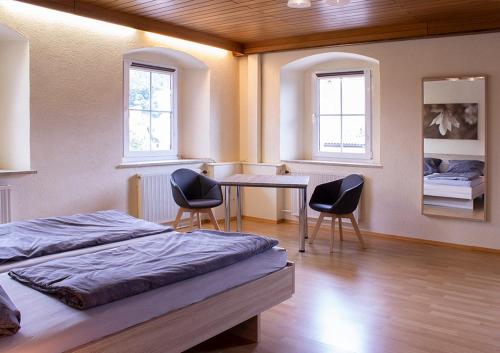 um quarto com 2 camas, uma mesa e 2 cadeiras em Schöne Ferienwohnung mit großer Terrasse. em Schmidmühlen
