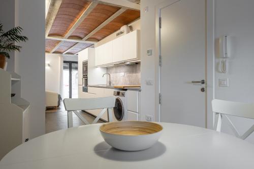 a white kitchen with a bowl on a table at Hauzify I Apartaments Montblanc in Montblanc