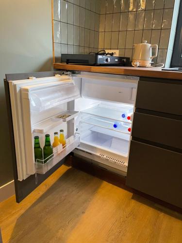 an open refrigerator with drinks in it in a kitchen at B&B De Meije in Nieuwkoop