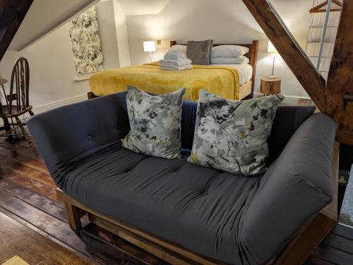 a couch with pillows in a room with a bed at Lake View Country House in Grasmere