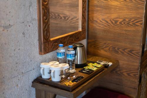 a wooden table with bottles of water on it at Foremanson Cave Hotel in Nar