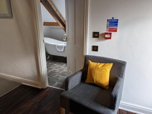a chair with a yellow pillow in a bathroom at Lake View Country House in Grasmere