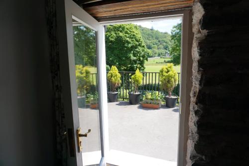 an open door to a patio with potted plants at Lake View Country House in Grasmere