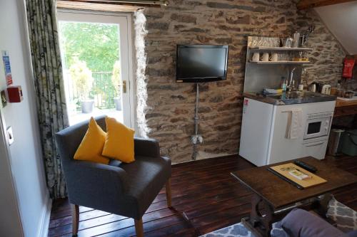 a living room with a chair and a tv on a wall at Lake View Country House in Grasmere