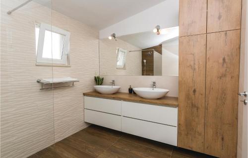 Baño con 2 lavabos y espejo en Stunning Home In Galovac With Wifi, en Galovac